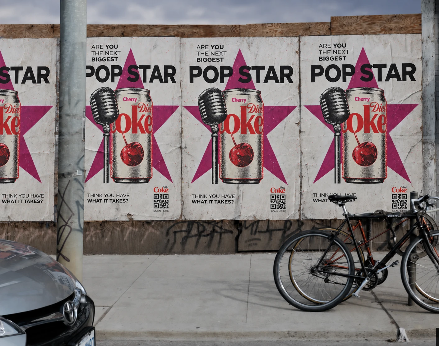 Wheatpasted posters on a street hoarding: 'Are you the next biggest Pop Star? Think you have what it takes?' with a microphone, a can of Diet Coke Cherry and a QR code