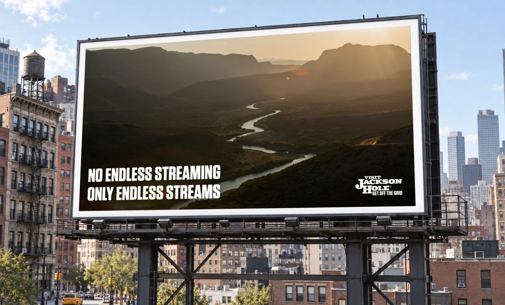 Billboard: 'No endless streaming, only endless streams,' over a river winding through a canyon at sunset